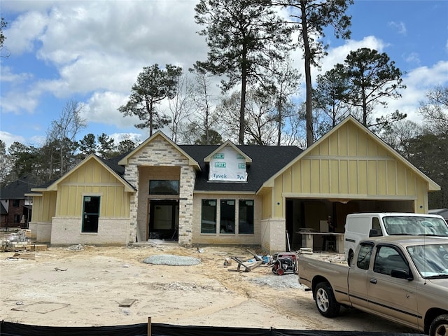 view of front facade featuring stone siding, board and batten siding, roof with shingles, and an attached garage