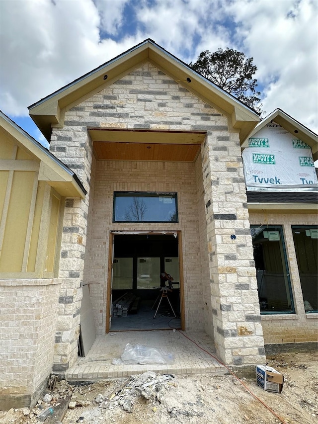 view of exterior entry with stone siding and brick siding