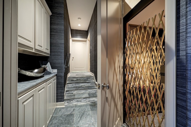 kitchen with light stone countertops, tile floors, and white cabinetry