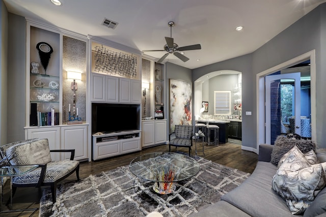 living room with dark hardwood / wood-style flooring and ceiling fan