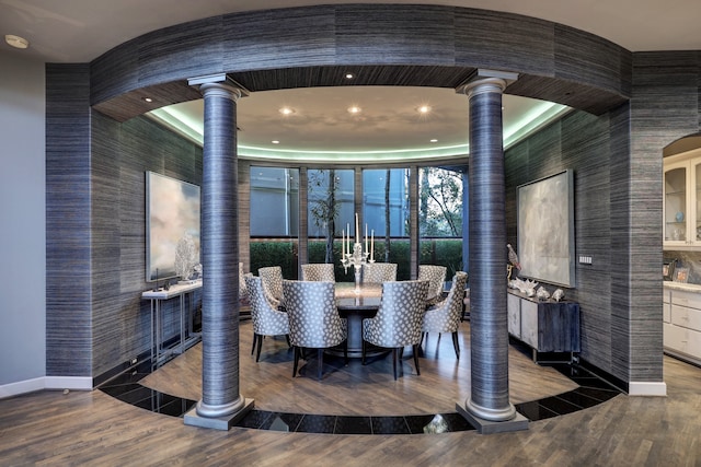 dining space with dark hardwood / wood-style floors and decorative columns