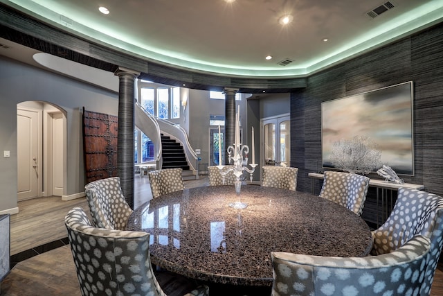 dining area featuring decorative columns and dark hardwood / wood-style floors