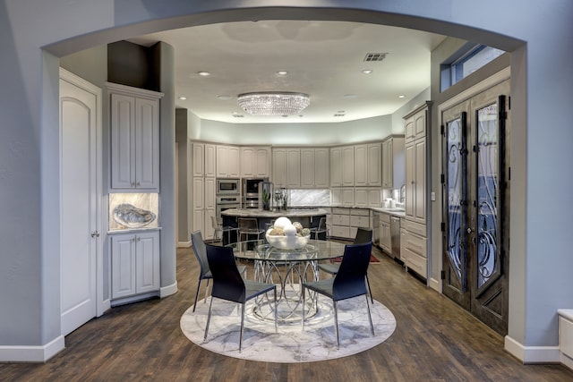 kitchen featuring french doors, a kitchen island, backsplash, a breakfast bar area, and dark wood-type flooring