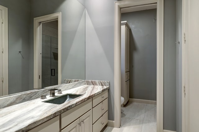 bathroom with toilet and large vanity