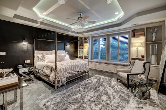 bedroom with ceiling fan and a raised ceiling