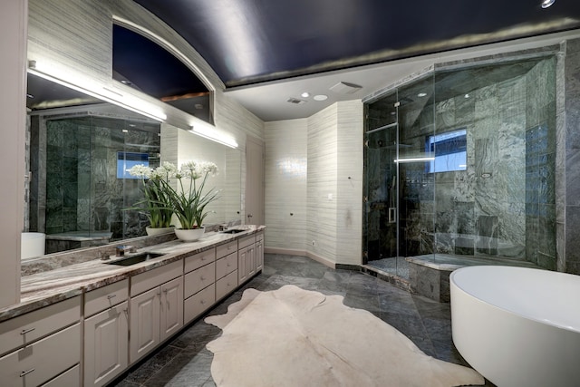 bathroom with tile walls, shower with separate bathtub, tile floors, and dual vanity