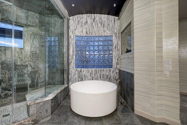 bathroom with tile walls, tile floors, and plus walk in shower