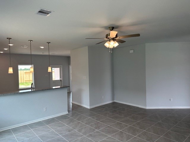 interior space featuring dark tile patterned flooring and ceiling fan