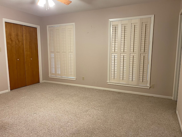 unfurnished bedroom featuring two closets, ceiling fan, and carpet floors