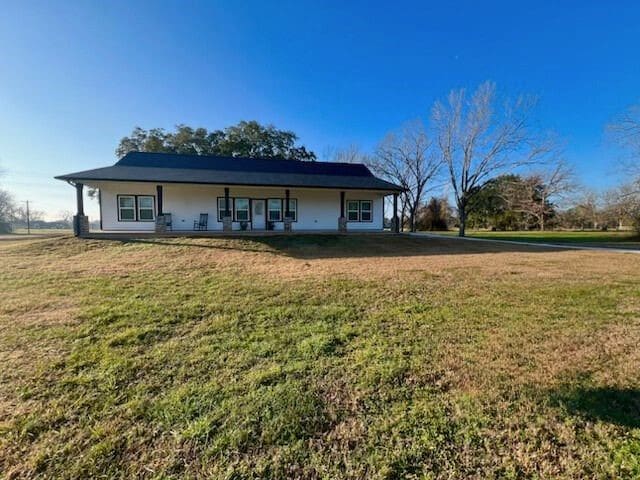 rear view of property with a lawn