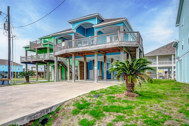 back of house featuring a balcony and a lawn