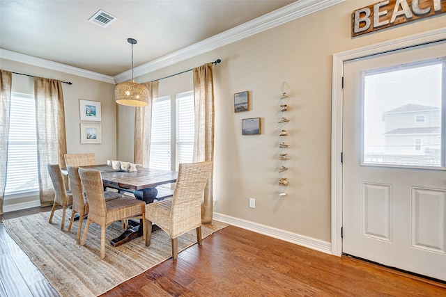 dining room with ornamental molding, dark hardwood / wood-style floors, and a healthy amount of sunlight