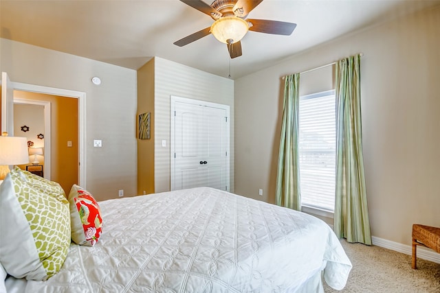 bedroom with ceiling fan, a closet, and light carpet