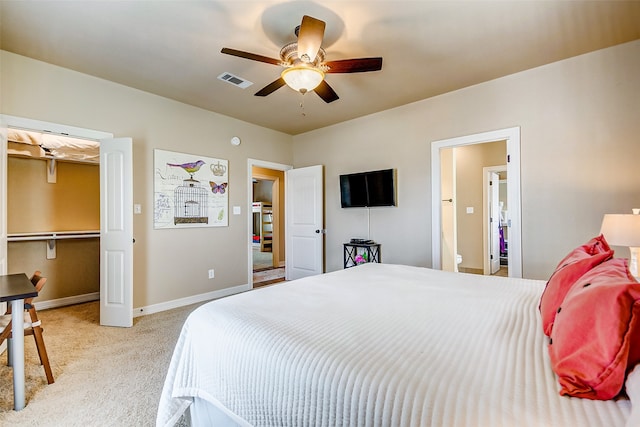 bedroom with ceiling fan, a spacious closet, and light colored carpet