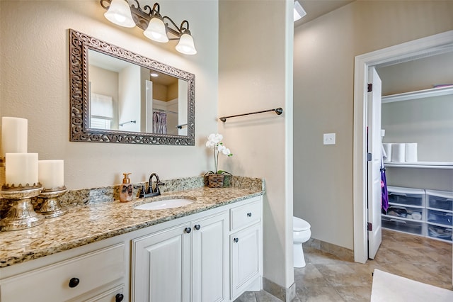 bathroom with toilet, oversized vanity, and tile flooring