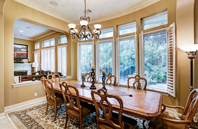 dining space featuring ornamental molding, a notable chandelier, and light tile patterned floors