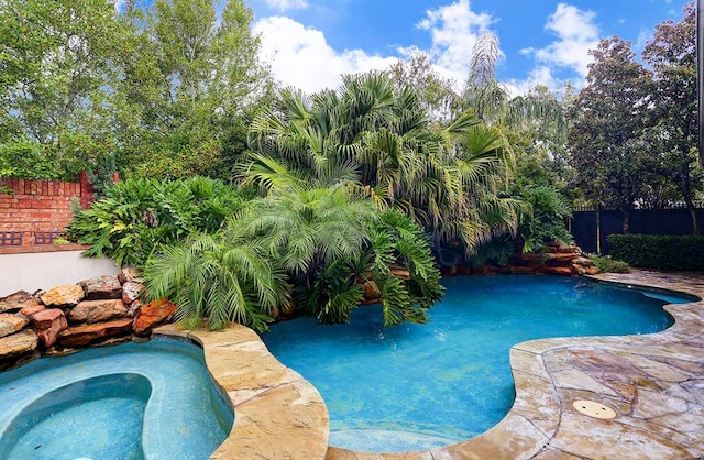 view of swimming pool with an in ground hot tub