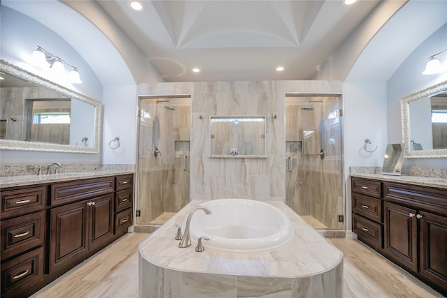 bathroom with tile floors, separate shower and tub, lofted ceiling, and vanity