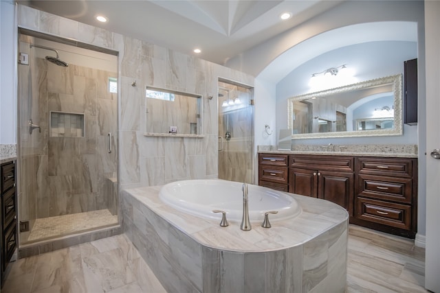 bathroom with tile flooring, vanity, and independent shower and bath