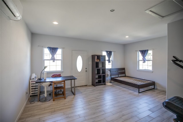 entrance foyer with light hardwood / wood-style flooring, a wealth of natural light, and a wall unit AC