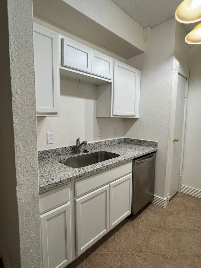 kitchen featuring stainless steel dishwasher, white cabinetry, and sink