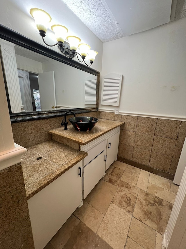 bathroom with a textured ceiling, tile flooring, and large vanity