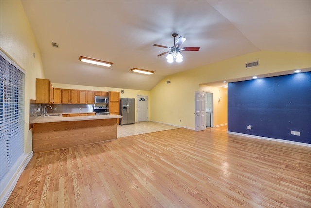 kitchen with ceiling fan, stainless steel appliances, light hardwood / wood-style flooring, and kitchen peninsula