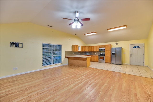 kitchen featuring ceiling fan, vaulted ceiling, stainless steel appliances, and light hardwood / wood-style floors