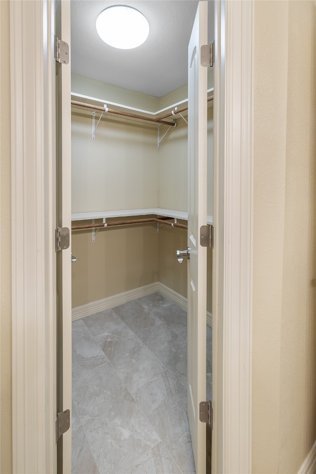 spacious closet featuring light tile flooring