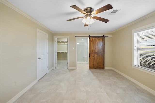 unfurnished bedroom with a barn door, light tile floors, a closet, ceiling fan, and a walk in closet