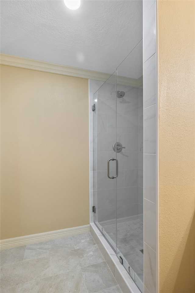 bathroom featuring crown molding, tile floors, a shower with door, and a textured ceiling