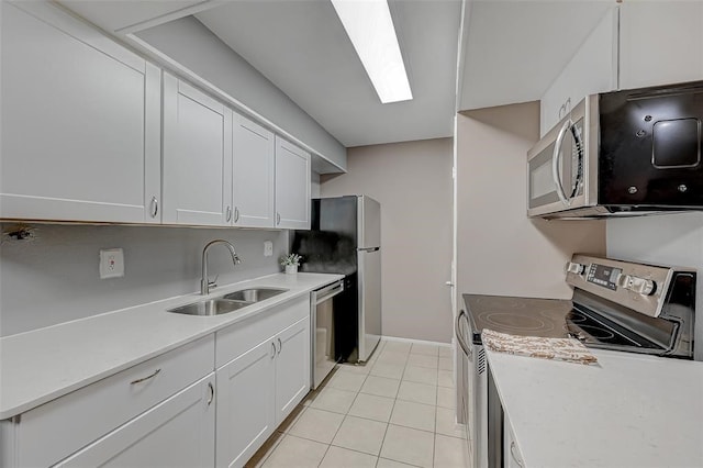 kitchen featuring sink, stainless steel appliances, white cabinetry, and light tile floors