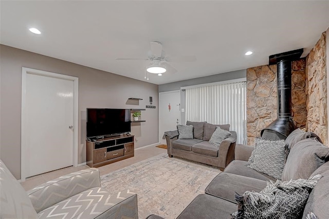 living room with ceiling fan and a wood stove