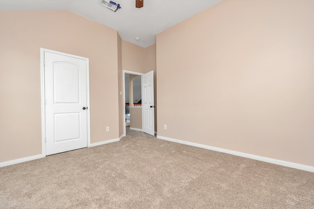 unfurnished bedroom featuring light carpet, lofted ceiling, and ceiling fan