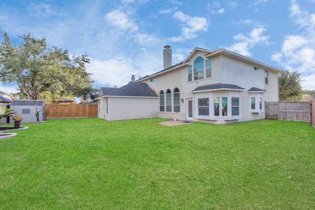 rear view of property featuring a storage shed and a yard