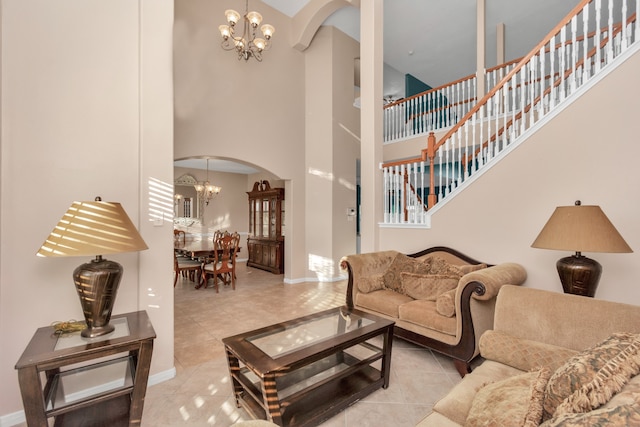 living room with an inviting chandelier, light tile flooring, and a high ceiling