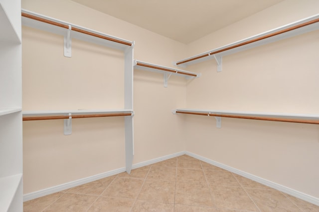 walk in closet featuring light tile floors