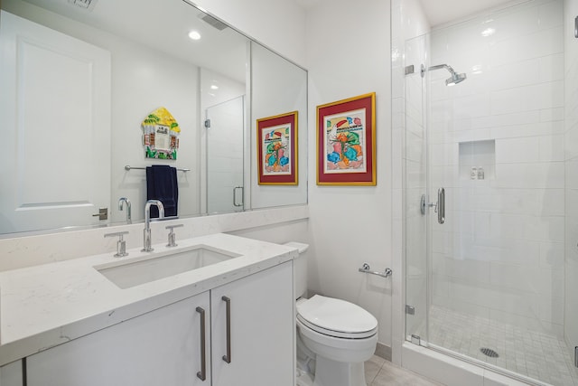 bathroom with tile floors, toilet, vanity, and an enclosed shower