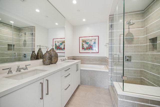 bathroom featuring double sink, tile floors, oversized vanity, and shower with separate bathtub