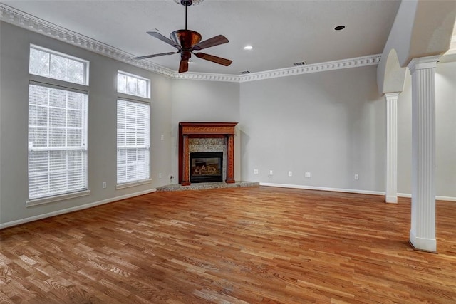 unfurnished living room with plenty of natural light, ceiling fan, light hardwood / wood-style floors, and decorative columns