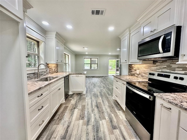 kitchen featuring backsplash, white cabinetry, appliances with stainless steel finishes, and sink