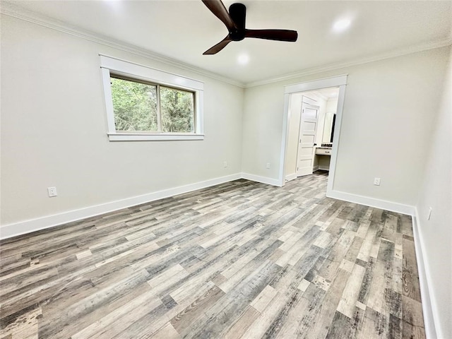 empty room featuring ornamental molding, ceiling fan, and light wood-type flooring