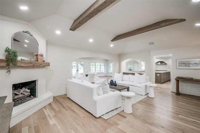 living room with lofted ceiling with beams and light wood-type flooring