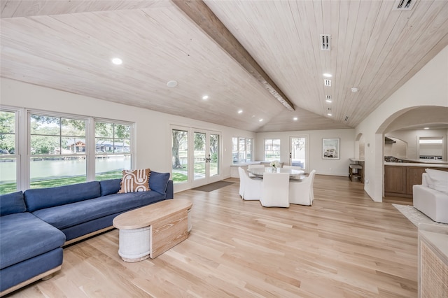 living room with lofted ceiling with beams, french doors, light hardwood / wood-style floors, and a wealth of natural light