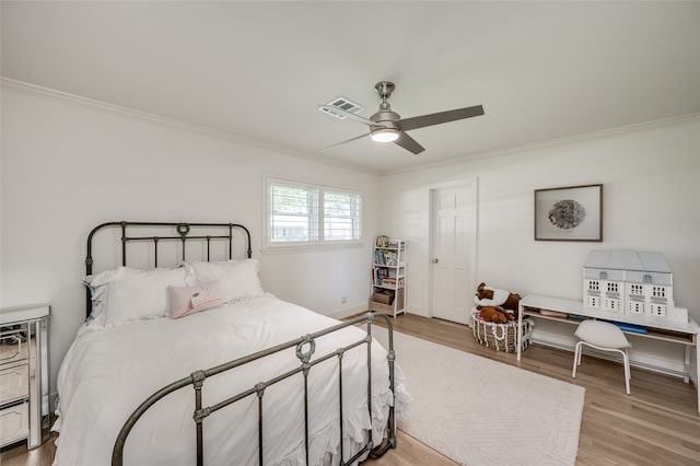 bedroom with crown molding, light hardwood / wood-style floors, and ceiling fan