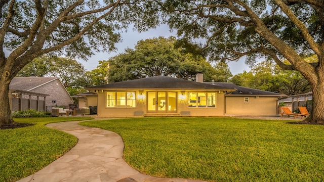 rear view of property featuring a yard, a patio, and central AC unit