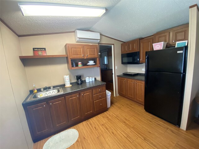 kitchen with black appliances, sink, light hardwood / wood-style flooring, a textured ceiling, and a wall mounted AC