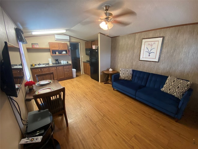 living room with lofted ceiling, ceiling fan, light hardwood / wood-style flooring, and a wall unit AC