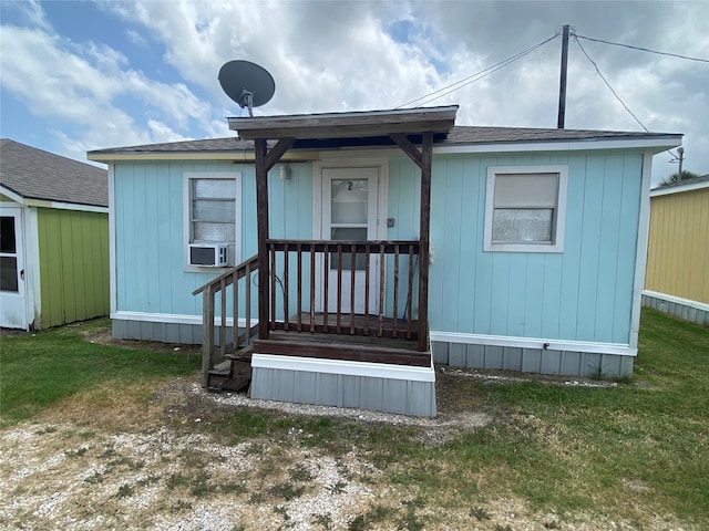 rear view of property featuring a lawn