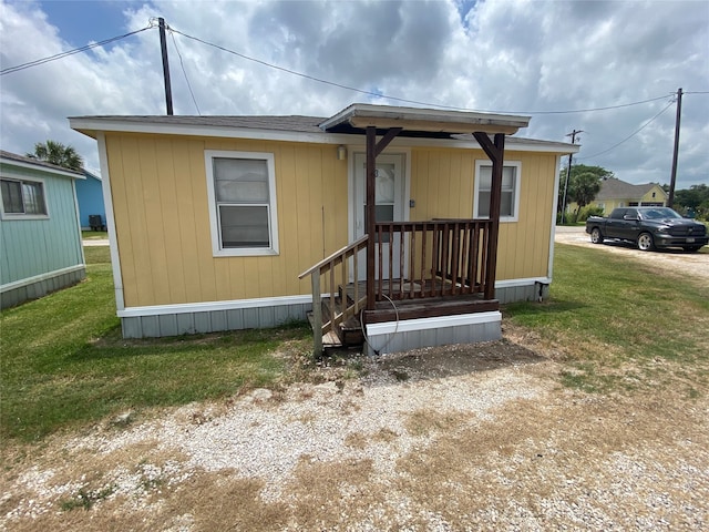 view of front of house featuring covered porch and a front lawn